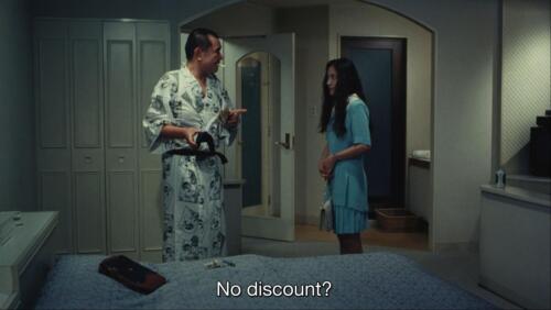 Rei and her client. Her client attempts to lowball her. The subtitle reads, "No discount?"
